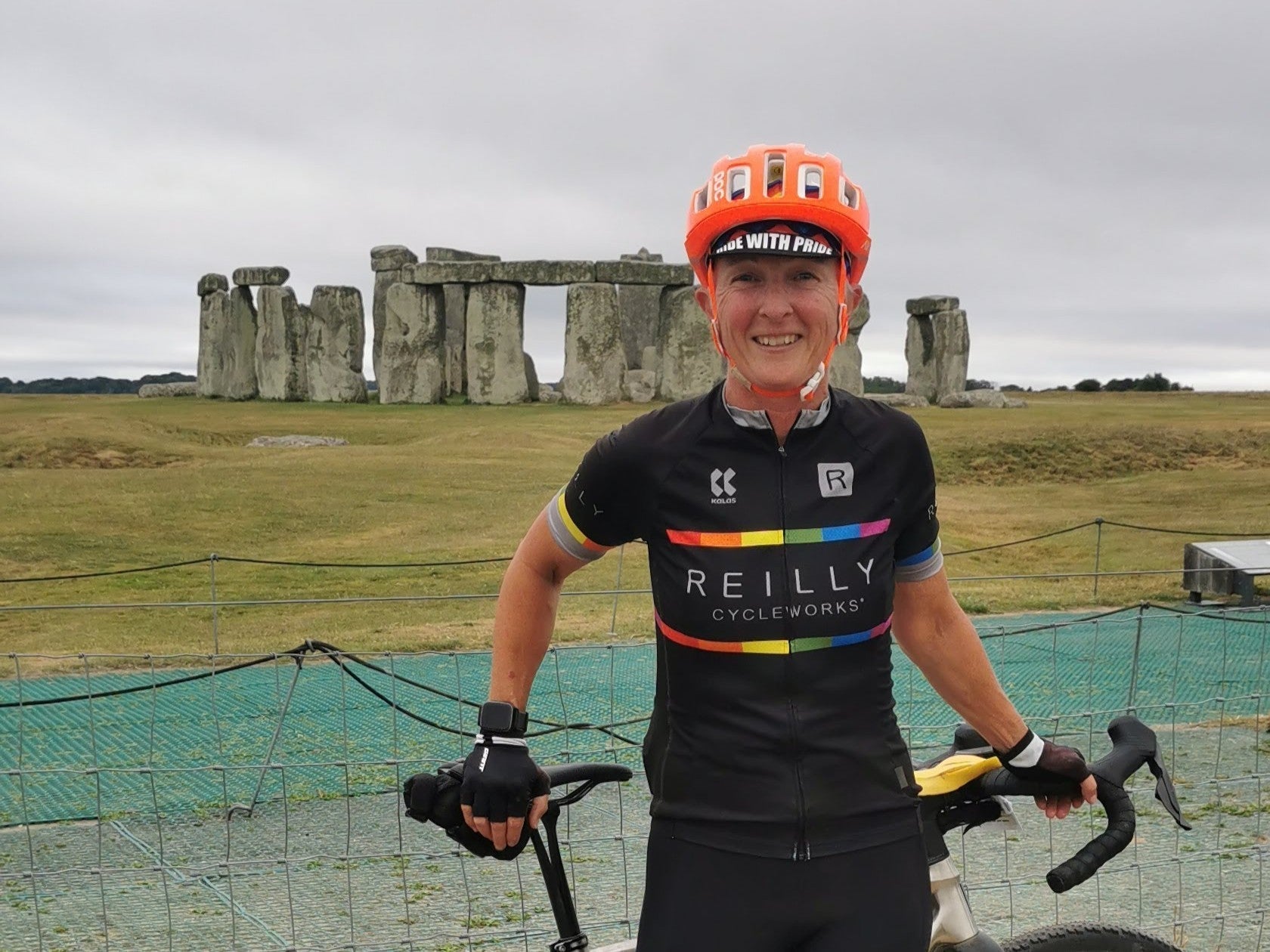 Female Cyclist poses infront of Stonehenge
