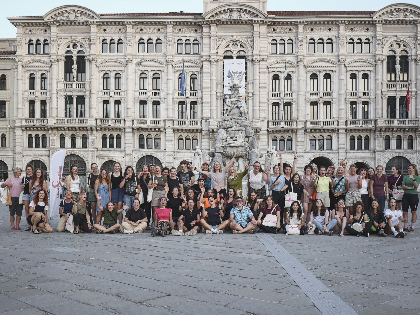 A group of women stand in front of an old building