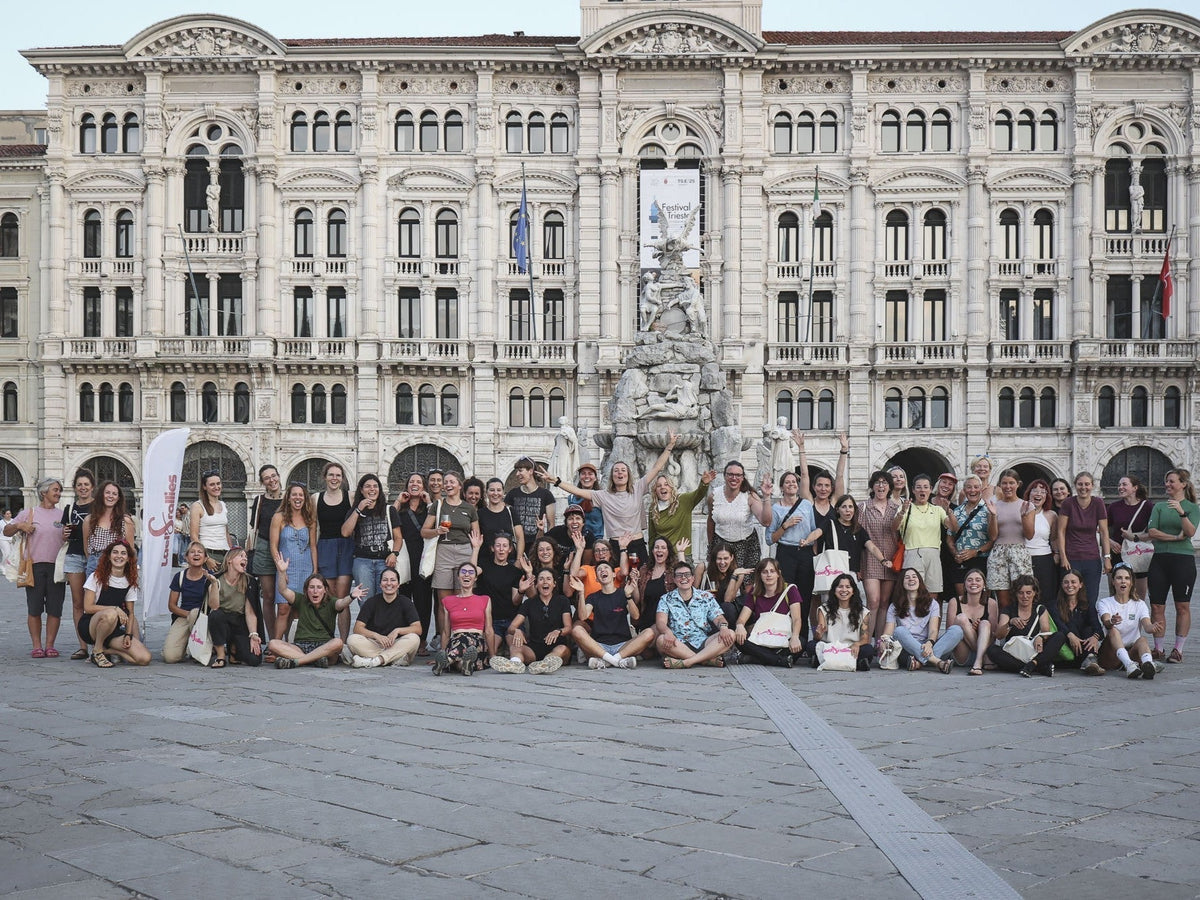 A group of women stand in front of an old building