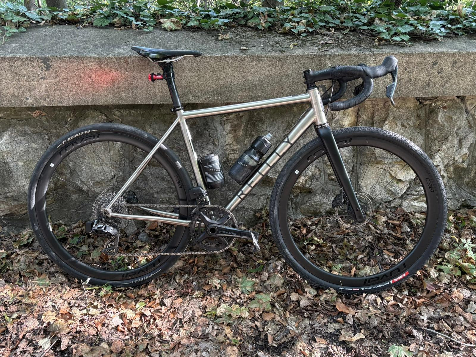A titanium bike against a wall.