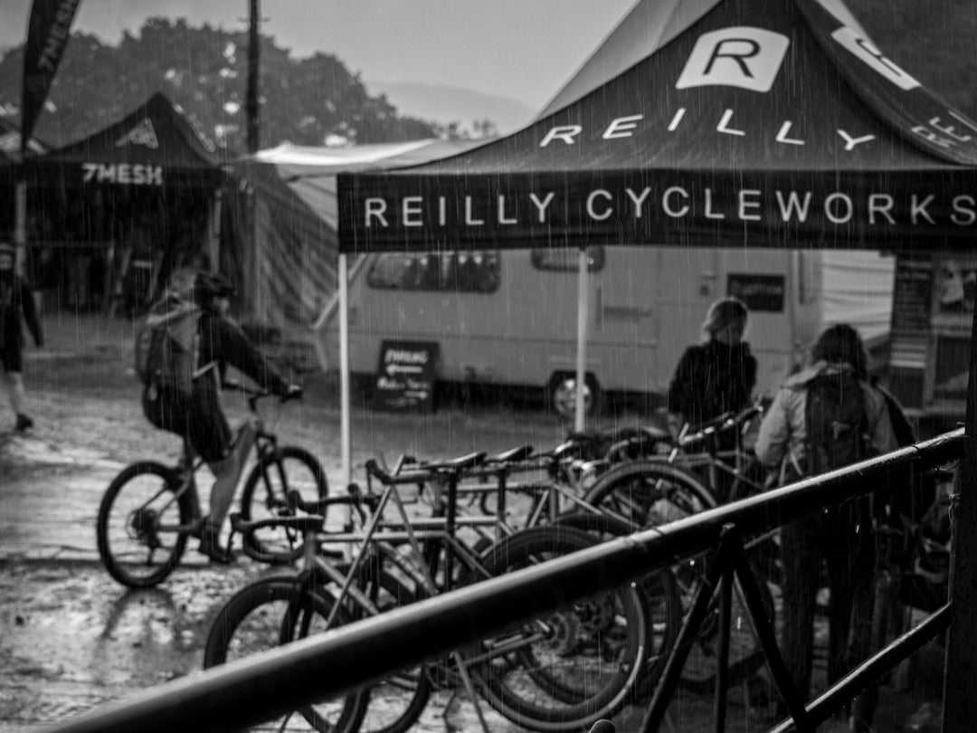Black and white image of a bike event with 'Reilly Cycleworks' tent.