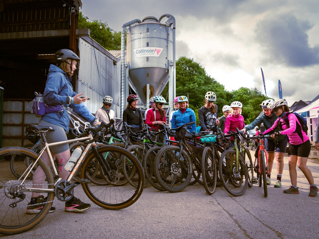 Group of cyclists with their bicycles near a building with a 'Cannondale' logo.