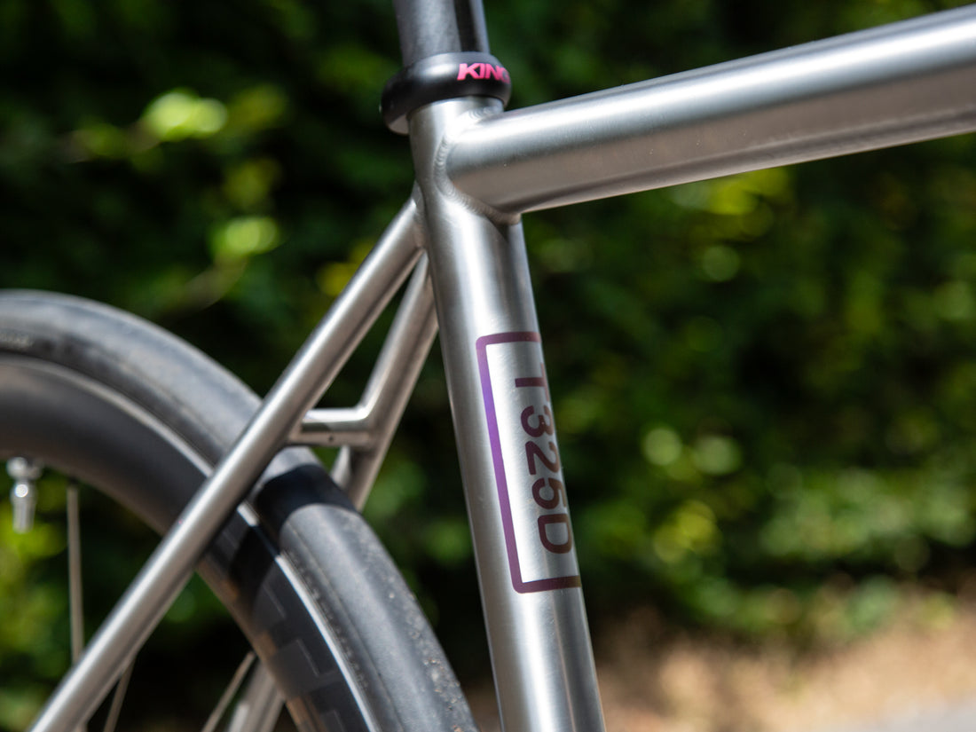 Close up of a titanium frameset with blurred background.