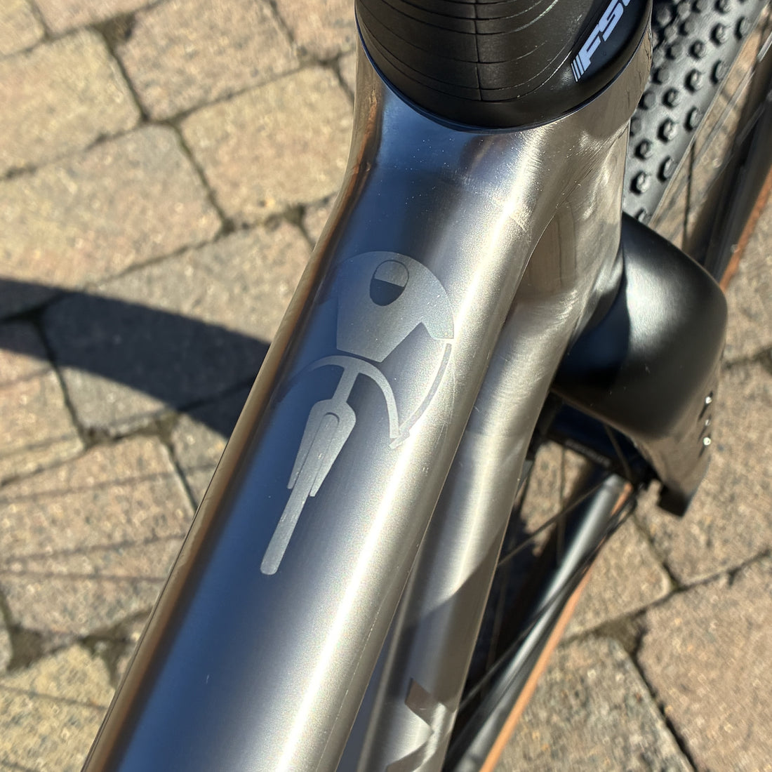 Logo of a cyclist on a titanium bike