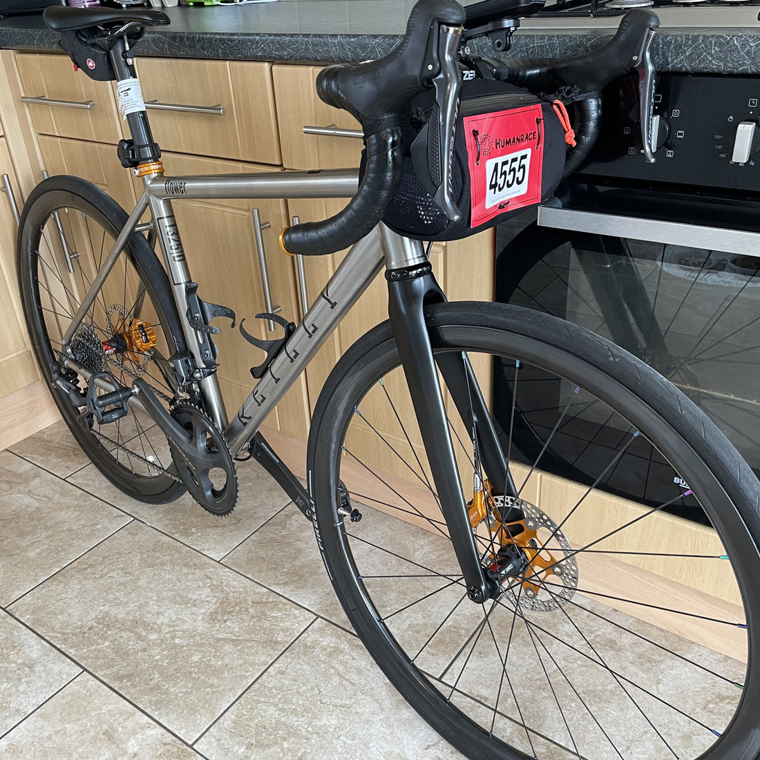 a silver 'reilly' bike stood in a kitchen.