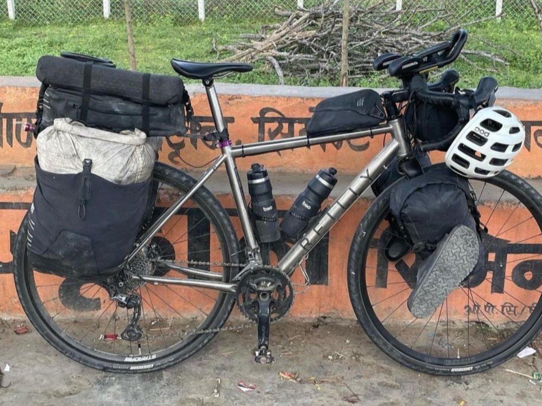 A titanium road bike loaded with bags