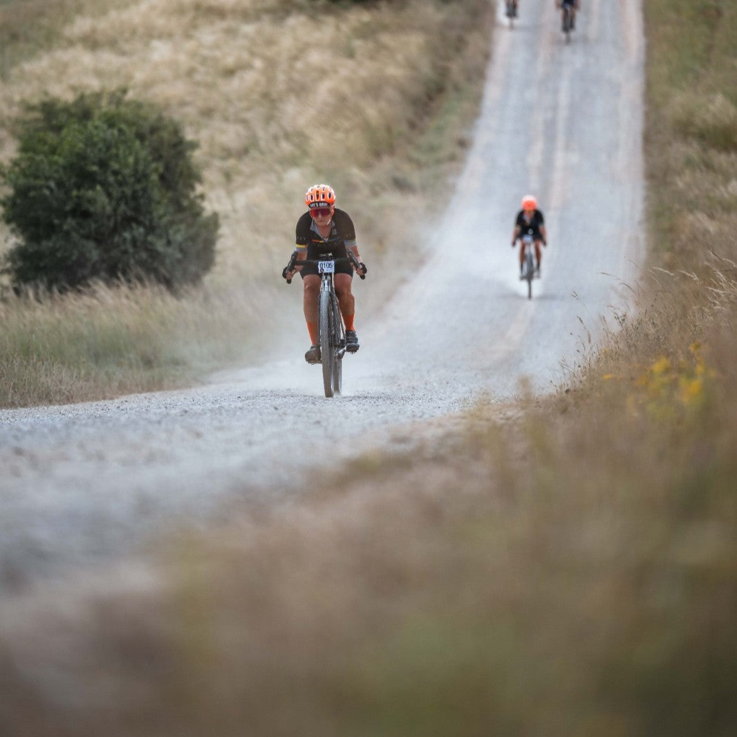 Two cyclists on a gravel road with a blurred background