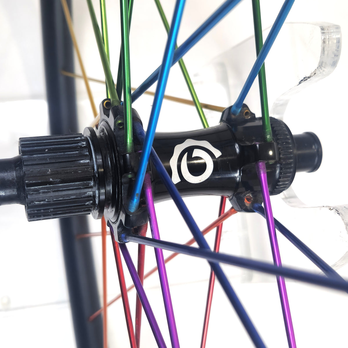 Close-up of a bicycle hub with colorful spokes on a white background