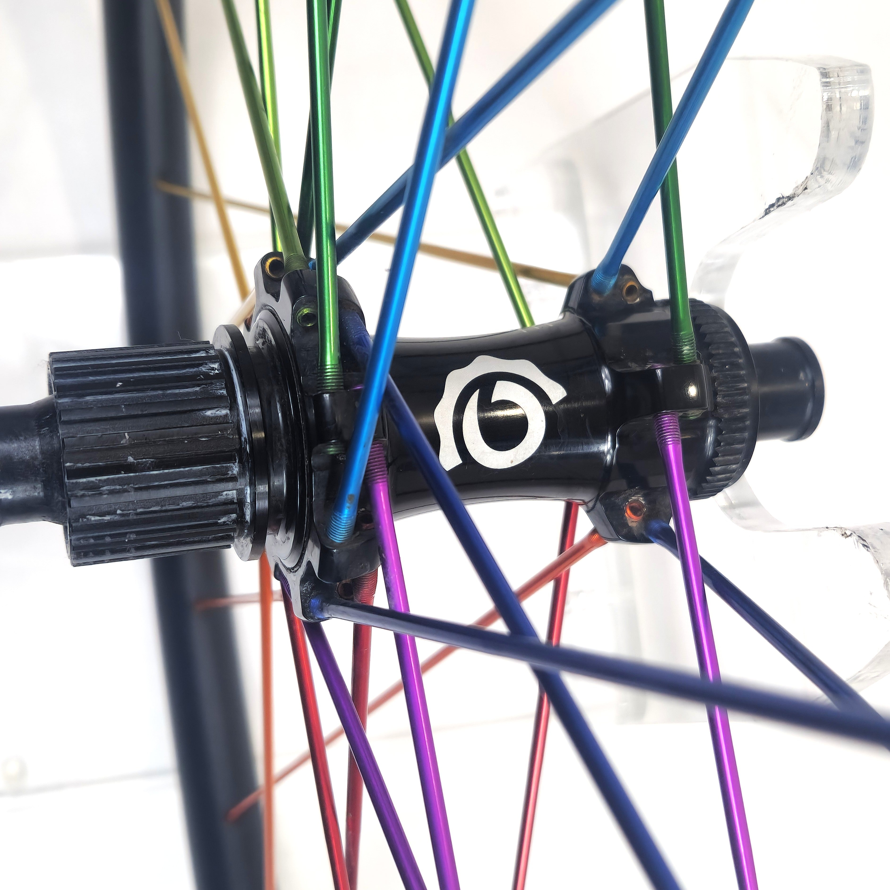 Close-up of a bicycle hub with colorful spokes on a white background