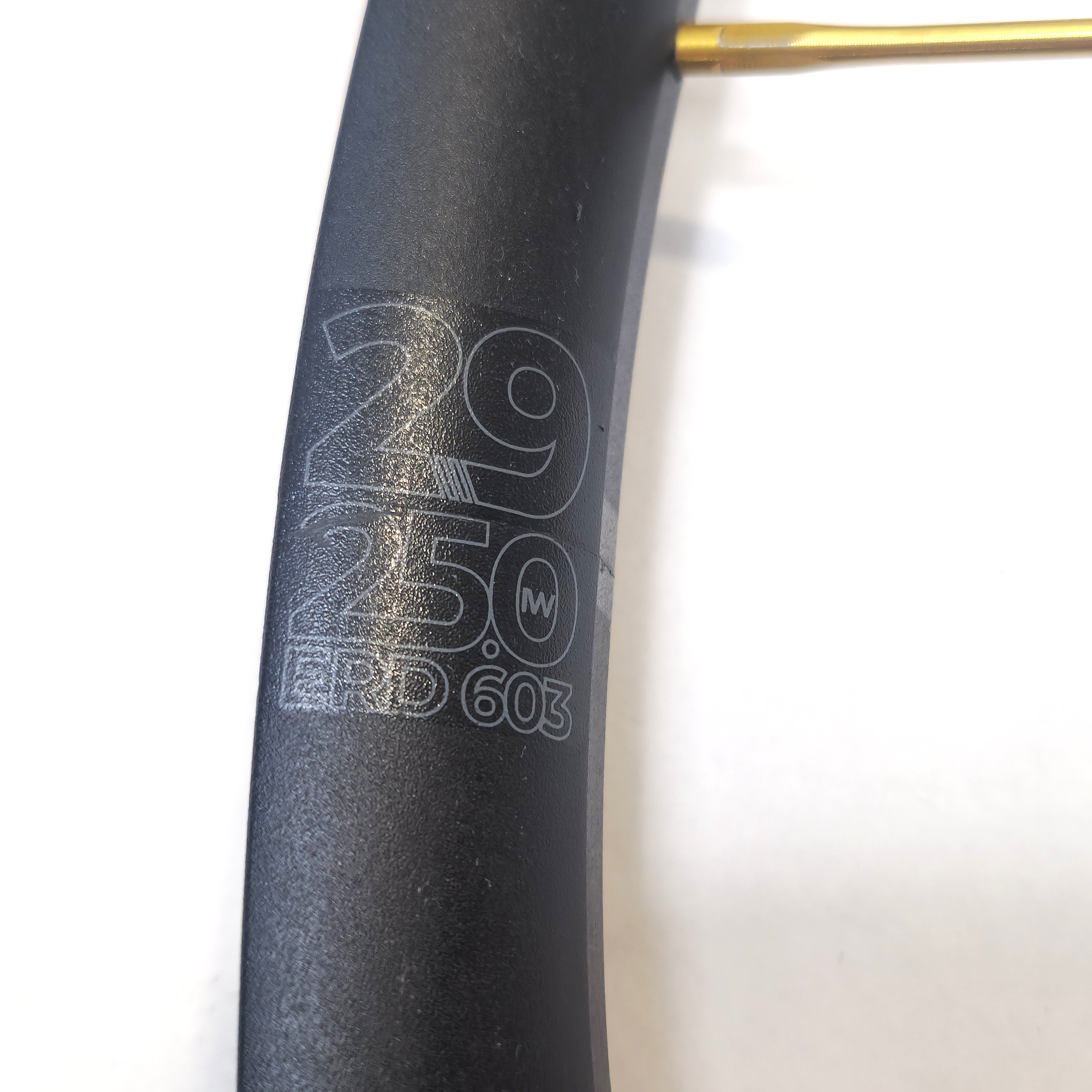 Close-up of a bicycle rim with specifications engraved on a white background