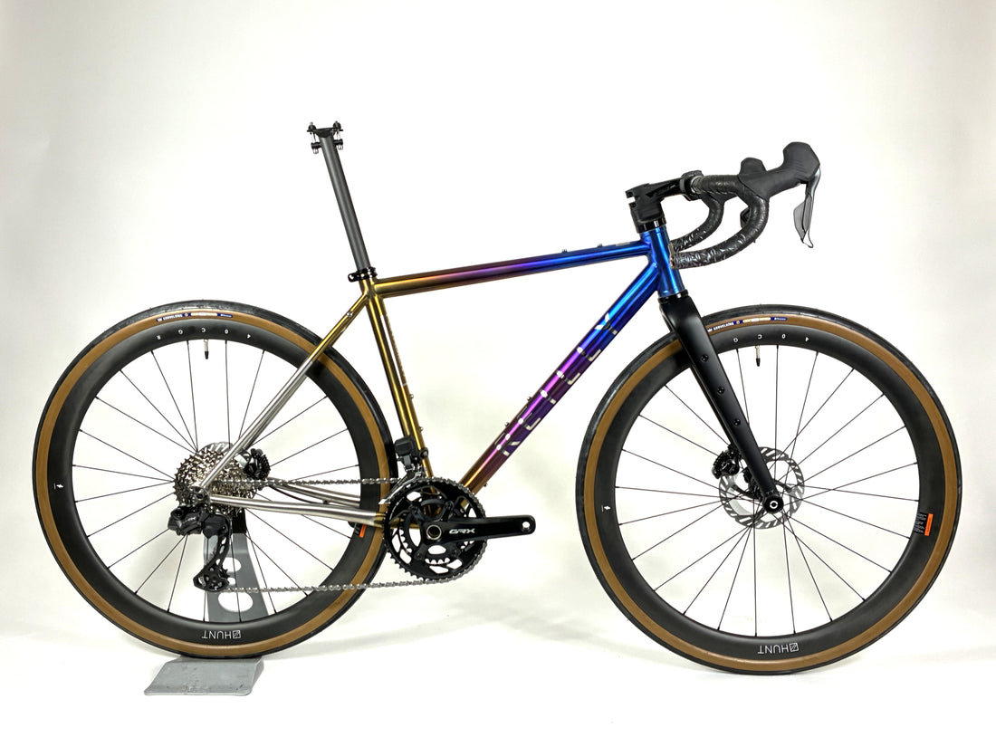 Multicolored anodised titanium bicycle on a white background