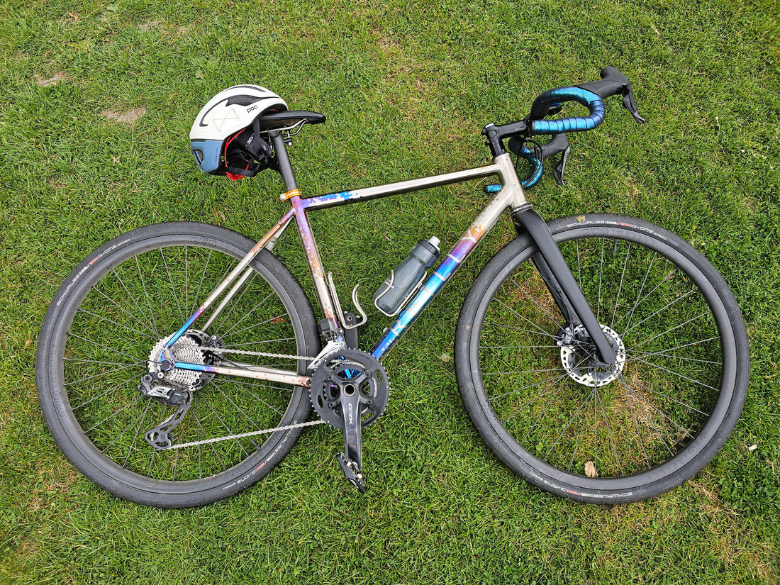 a chrome, anodised bike layed on the grass