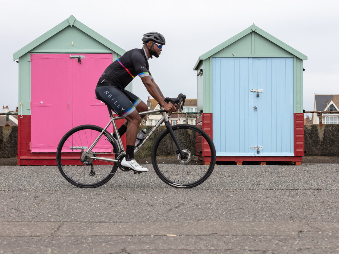 Cyclist riding a bike with colorful beach huts in the background