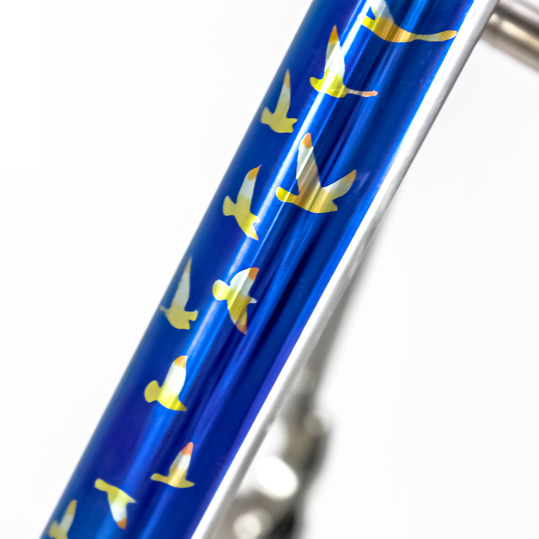 Birds flying across blue sky pattern printed onto a titanium road bike