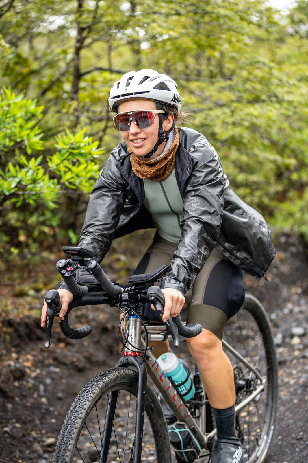 Woman cycling on a trail with greenery in the background