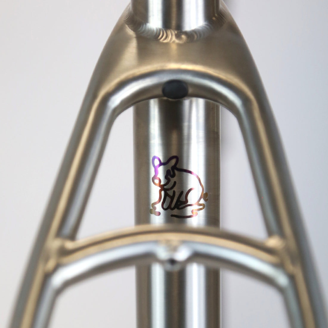 Outline of a pig anodized onto a titanium bike frame 