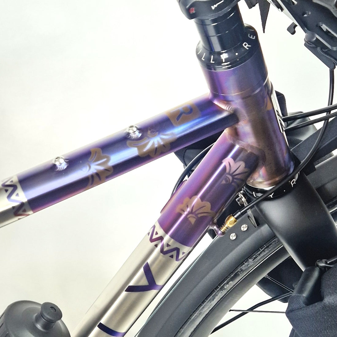 Close-up of a bicycle frame with purple and white design on a white background