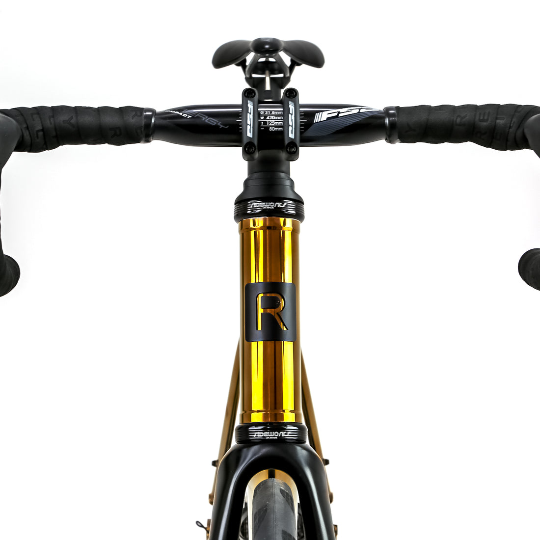 Polished gold Reilly road bike with black headtube badge and aero handlebars