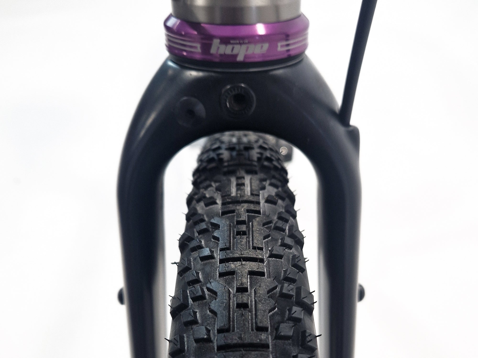 close up of a folk and purple headset with 'HOPE' branding on connecting with a gravel trye.