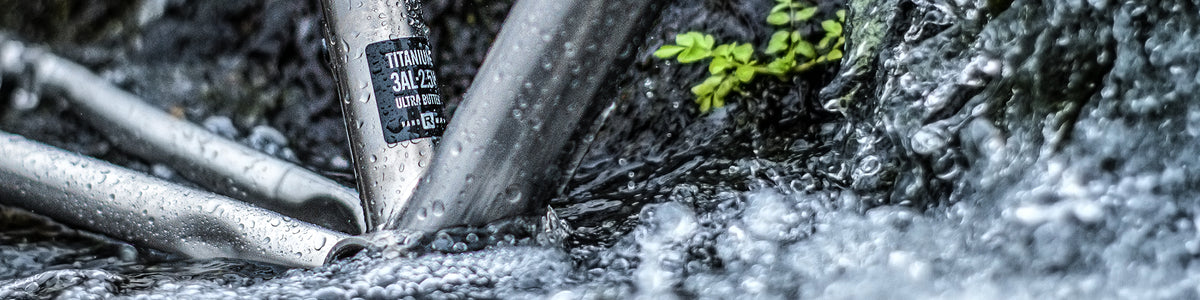 Close-up of a metallic bicycle frame tube in flowing water