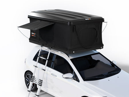 A black rooftop tent mounted on the roof of a white hatchback car, shown on a clean white studio background. The tent has an extended side flap, a black ladder, and visible Tents 3 branding.
