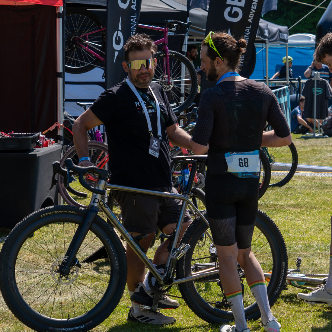 Two men chat over a bike.