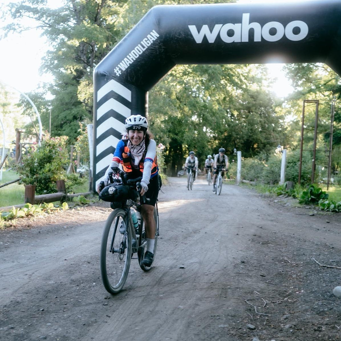 A woman cycles under the gantry at a gravel race.