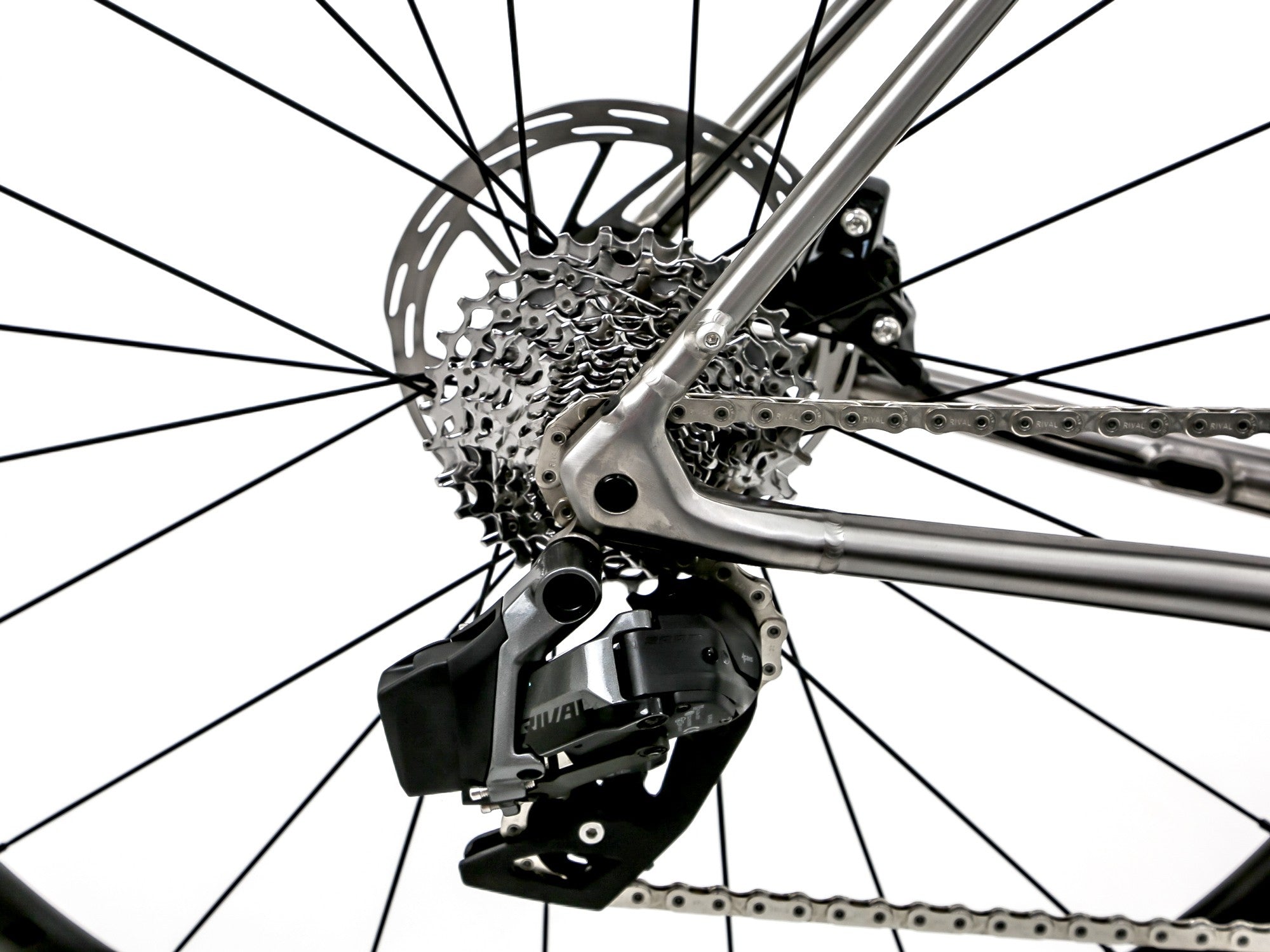 Close-up of a bicycle's rear wheel hub, cassette, chain, and derailleur against a white background.