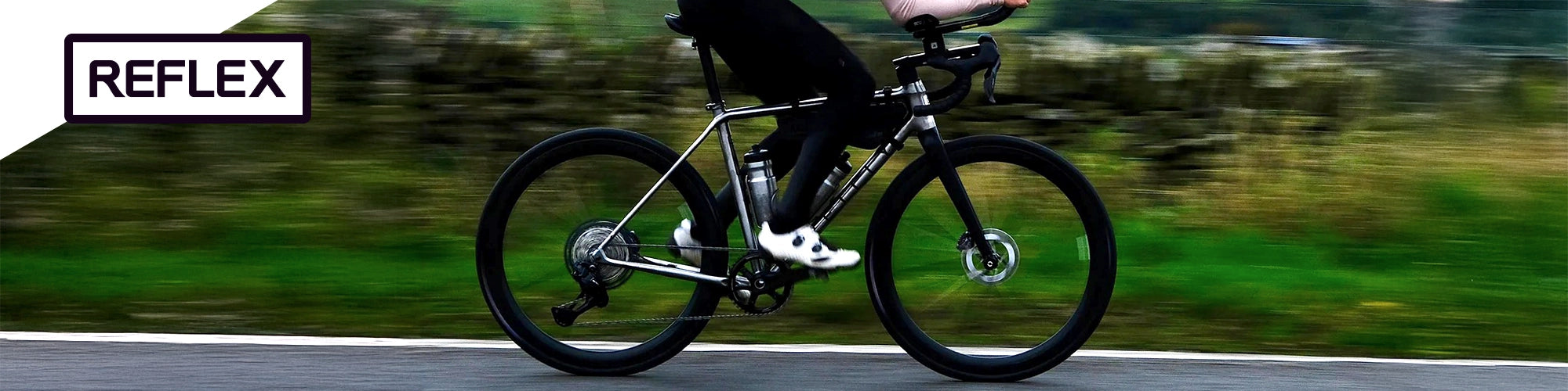 Person riding a bicycle on a road with 'REFLEX' branding.