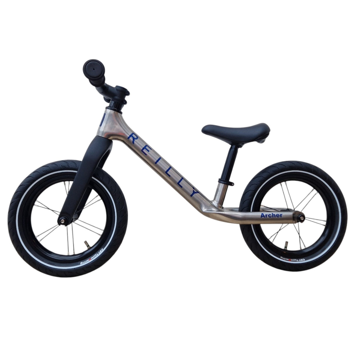 A titanium balance bike on white.