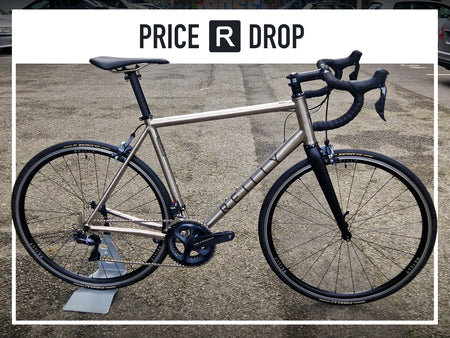 Titanium bike on tarmac.