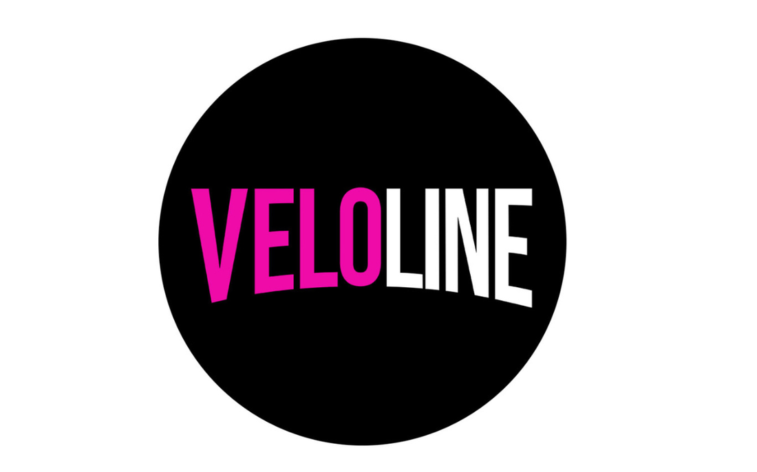 Black circle with 'VELOLINE' text in pink and white on a white background
