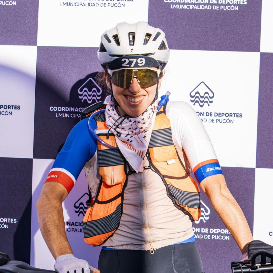 A woman cyclist stands infront of branding board.