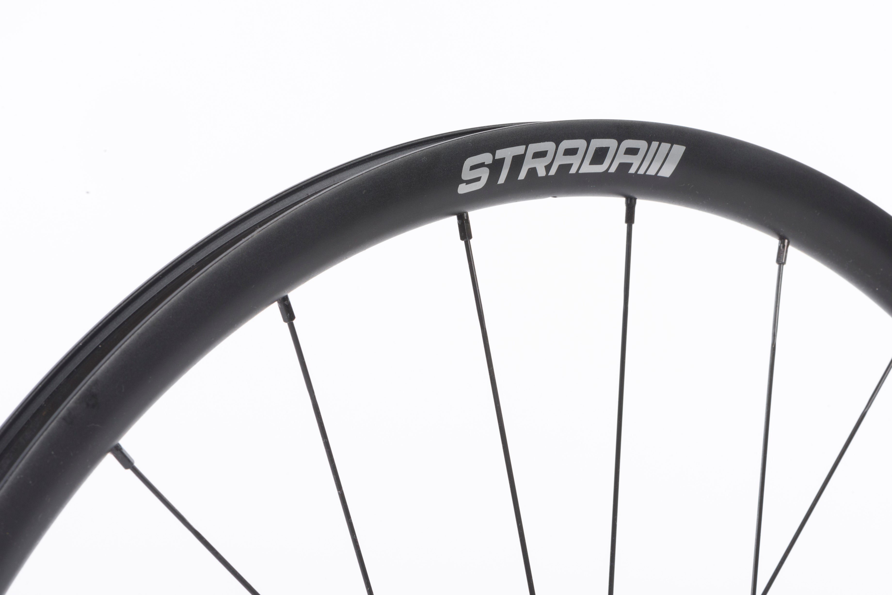 A close up of the STRADAI logo on a wheel on white background