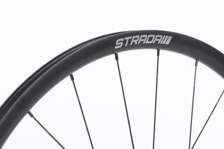 A close up of the STRADAI logo on a wheel on white background